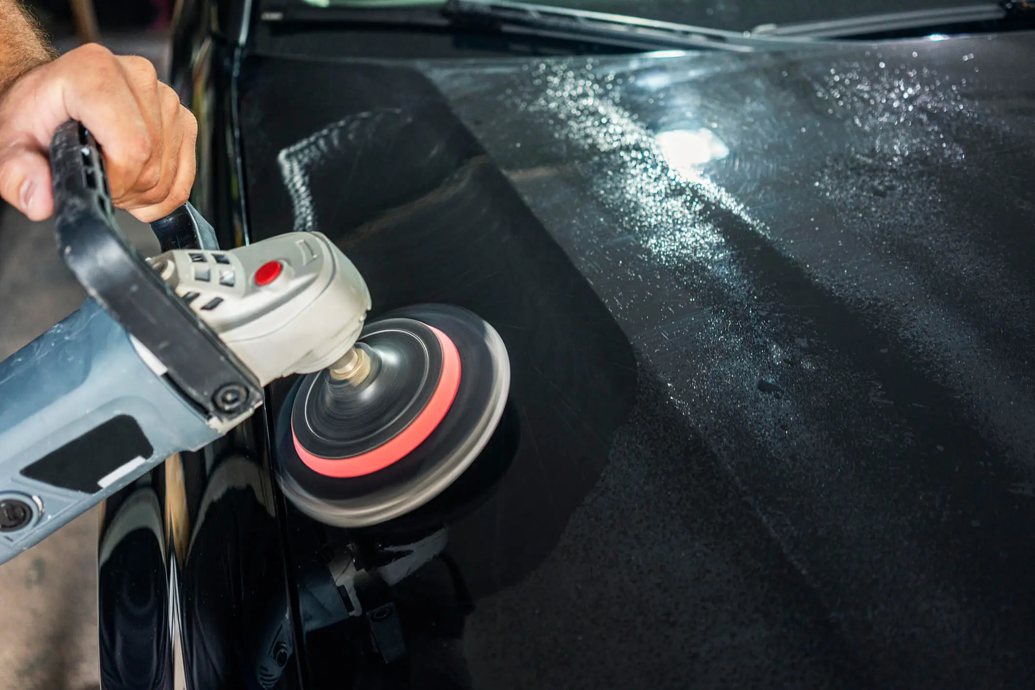 Car polishing with electric buffer tool.