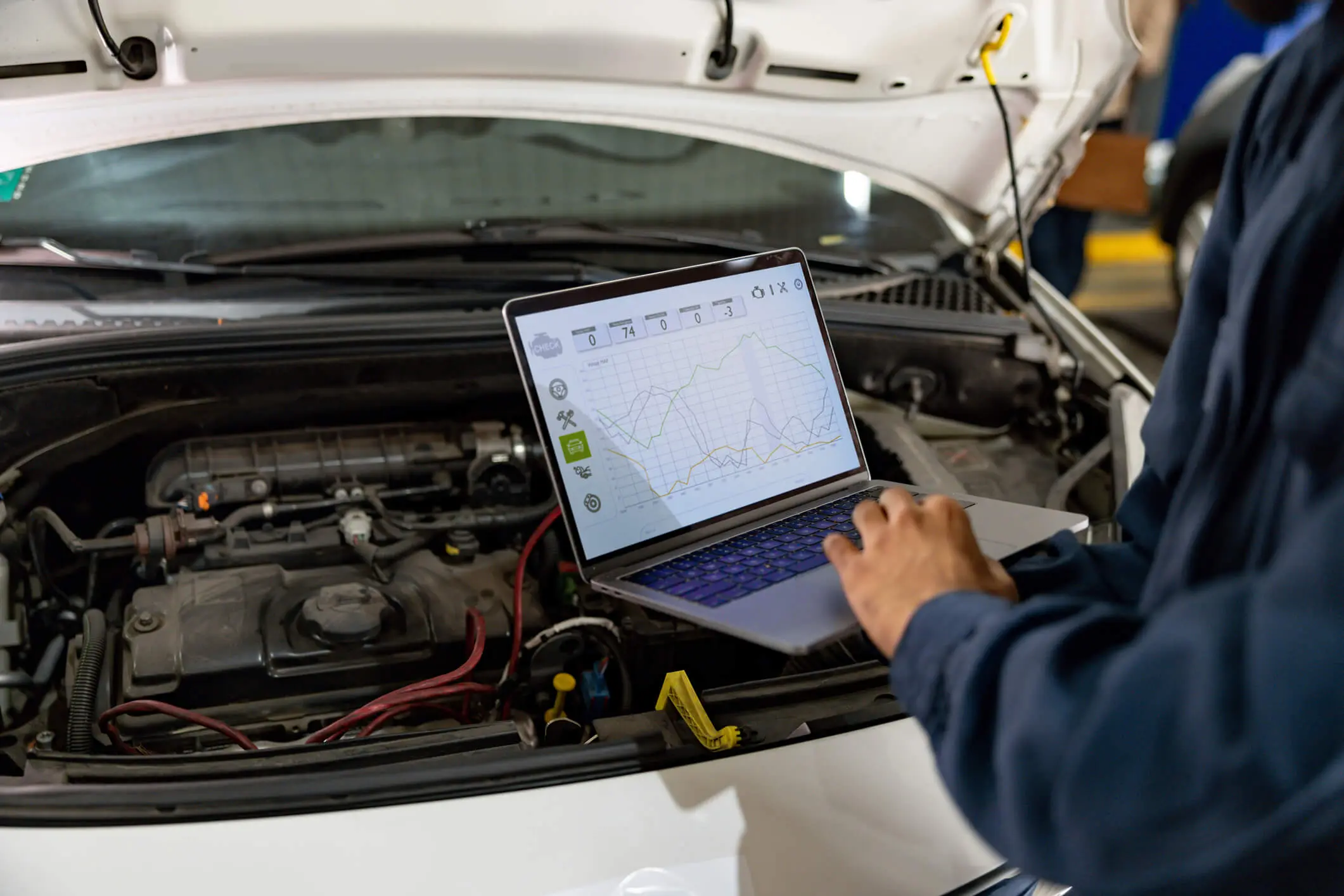 Mechanic using laptop for car diagnostics.